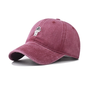 Detailed close-up of astronaut embroidery on burgundy washed cotton baseball cap