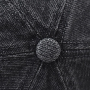 Macro detail of charcoal grey washed denim baseball cap crown and reinforced stitching