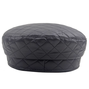 Detail of black quilted leather beret hat showing texture and diamond stitch patterns