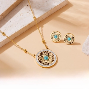 Detailed close-up of gold hollow out pendant necklace and turquoise earrings set