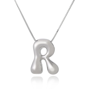 Polished silver 3D letter R pendant on a thin box chain with a soft shadow reflection