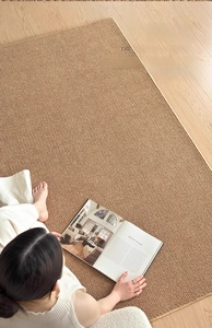 Detail of woven sisal texture rug in golden brown on a minimalist light wood floor