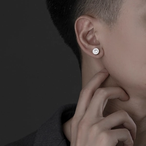 Close-up of a silver earring with sparkling cubic zirconia on a model's earlobe