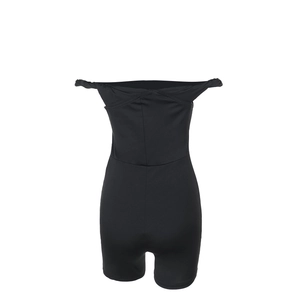 Vista dettagliata in piano della tutina nera slim fit con spalle scoperte da donna