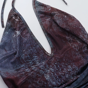 Détail du décolleté en V dos nu avec imprimé marbré sur une robe moulante sexy