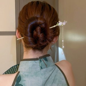 Vue détaillée du pic à cheveux avec lapin en jade et pompons de perles sur un chignon