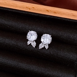 Close-up of silver rose zircon earrings displayed in a black velvet jewelry box