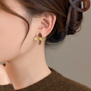 Vintage gold-rimmed amber flower stud earrings worn by model for elegant style