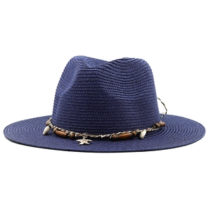 Close-up of navy straw sun hat with seashell, starfish charm and wooden bead accents