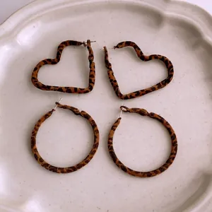 Brown leopard print earring set with heart and round designs in a ceramic tray