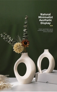Artistic cutout ceramic vase with grainy texture and dried eucalyptus in a dark setting