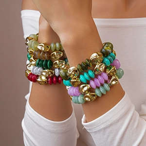 Detailed view of layered acrylic beaded bracelets with irregular gold metal accents