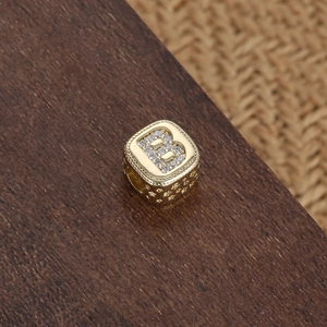 Perla cubica dorata con lettera B in zircone per braccialetti su base in legno
