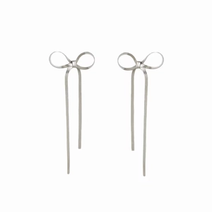 Boucles d'oreilles nœud papillon à franges en acier inoxydable sur un fond blanc pur