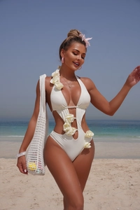 Detail of 3D white floral appliques and pearl chain on a white cut-out swimsuit
