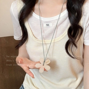Detail of beige floral pendant necklace on woven cord with Edition Atelier engraving