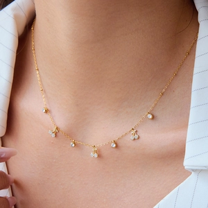 Elegante collana in acciaio al titanio dorato con ciondoli a ciliegia e piccoli diamanti