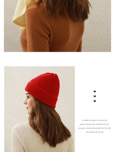 Detail of red knit beanie showing high-quality textured fabric and side profile on a model