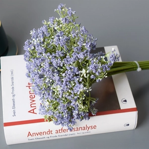 Detail view of purple artificial baby's breath bouquet on decorative white books