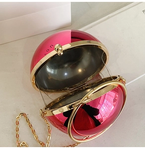 Vista interna di una borsa da sera sferica rosa con catena oro e scritta JOY