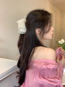 Side view of white mesh flower hair claw clip worn by a model for an elegant summer style