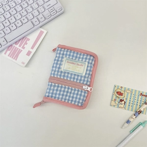 Detailed view of blue checkered quilted planner cover with pink zipper and front pocket