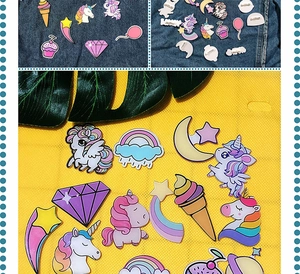 Detail of cute acrylic pins with unicorn and rainbow designs on denim fabric
