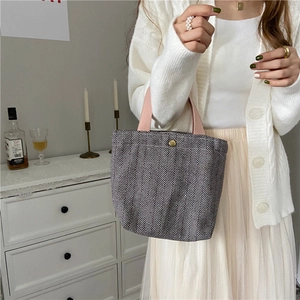 Fashionable herringbone pattern wool lunch bag with pink handles in lifestyle view