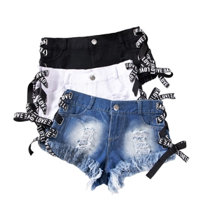 Dettaglio di pantaloncini di jeans a vita alta con frange e nastri LOVE incrociati