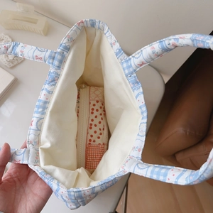 Internal view of quilted floral handbag showing a polka dot zipper inner pocket