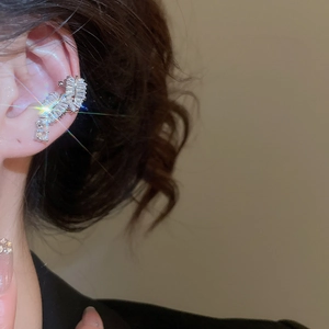 Detailed close-up of a silver ear cuff with leaf pattern and sparkling zircon stones