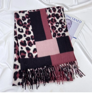 Detail of leopard print scarf with geometric color blocks and decorative fringes