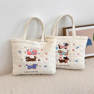 Detail of heart-quilted texture and cute cat embroidery on cream tote bag