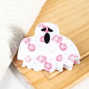 Détail d'une pince à cheveux fantôme avec motif floral rose sur plateau en bois