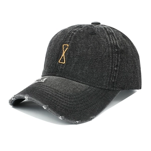 Detail of distressed brim and orange embroidery on vintage gray denim baseball cap