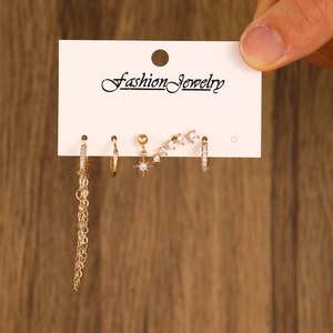 Detailed view of 5-piece gold ear piercing set with sparkling cubic zirconia on a card