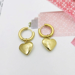 Golden titanium steel heart earrings with Forever Love engraving on flat lay background