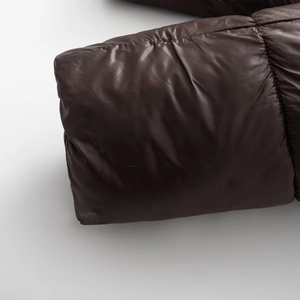 Detailaufnahme der schokoladenbraunen glänzenden Steppjacke mit horizontalen Nähten