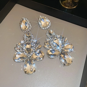 Close-up detail of silver chandelier earrings featuring teardrop and oval cut crystals