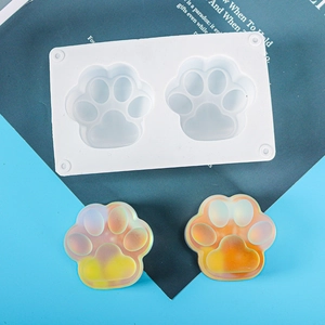 Macro view of white silicone cat paw molds with two colorful resin craft samples