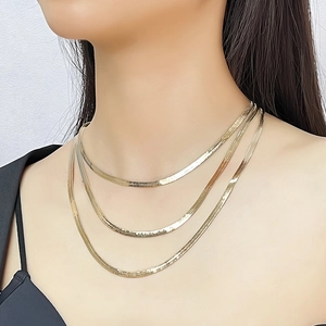 Detailed view of triple-layered golden snake chain necklace with sleek metallic texture