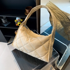 Detail of beige quilted nylon shoulder bag showing puffy texture and soft fabric finish