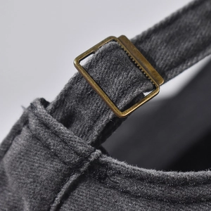 Vue macro de la boucle en bronze réglable sur la casquette en coton délavé gris