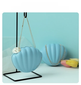 Blue shell-shaped gift box with gold bead chain and 'Life is Sweet' text detail
