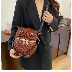 Detailed close-up of brown owl-shaped shoulder bag with embossed feather textures