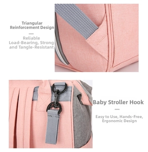 Detail of reinforced triangular stitching and stroller hooks on a pink oxford diaper bag
