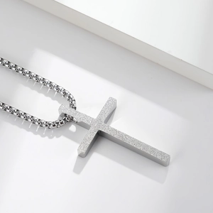 Polished silver titanium steel cross necklace with a frosted texture pendant on white background