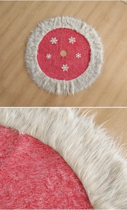 Detail of red Christmas tree skirt with plush grey faux fur edge and white snowflakes
