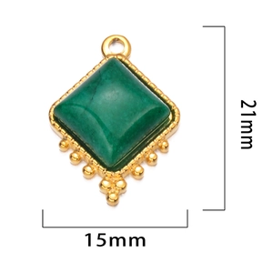 Détail d'un pendentif vintage en pierre verte avec cadre doré et mesures indiquées