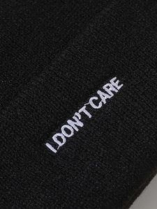 Nahaufnahme der 'I DON'T CARE' Stickerei auf einer hochwertigen schwarzen Strickmütze